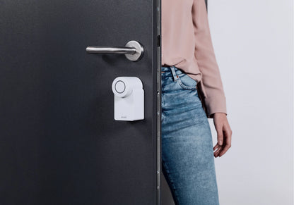 Mujer abriendo la puerta con el Nuki Smart Lock Go