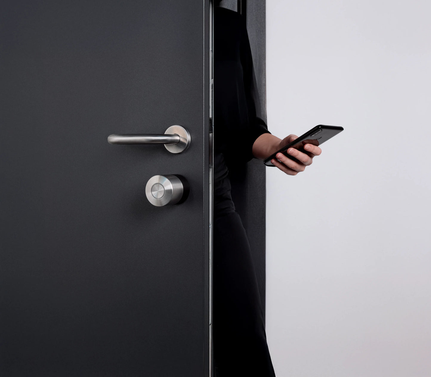 Persona abre la puerta con el Nuki Smart Lock Pro y el smartphone