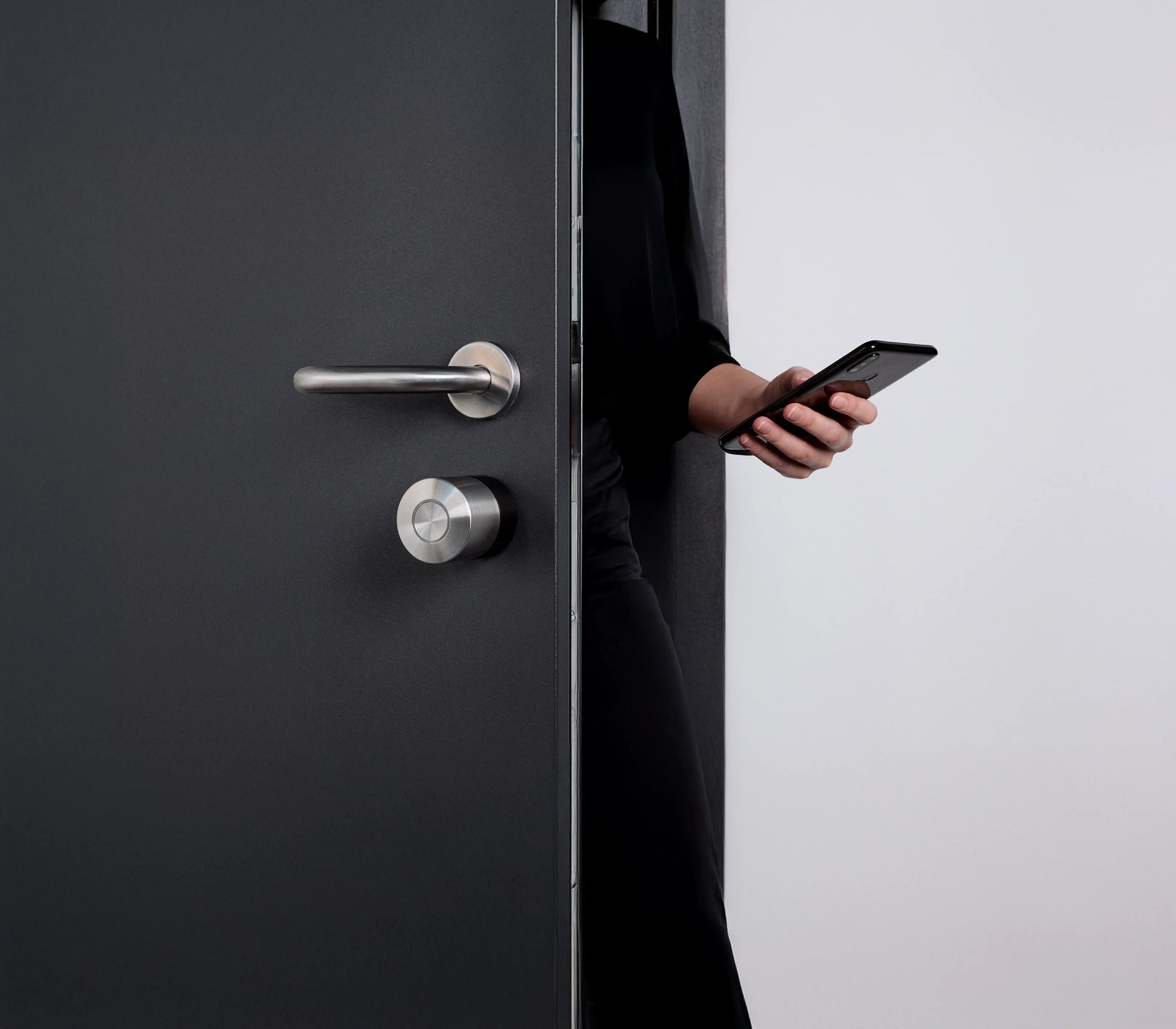 Persona abre la puerta con el Nuki Smart Lock Pro y el smartphone